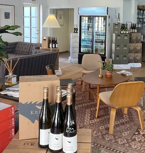 Indretning hos Villa Maris Kaffe- & Vinbar med vinkasser, loungemøbler og kaffebar