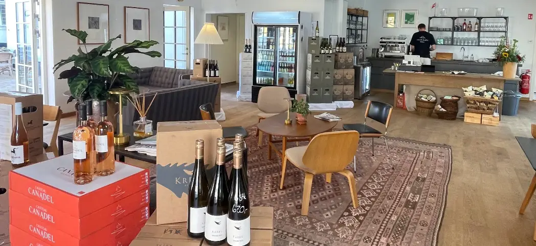 Villa Maris Kaffe- & Vinbar – Strandvejen 94, Lønstrup Indretning hos Villa Maris Kaffe- & Vinbar med vinkasser, loungemøbler og kaffebar