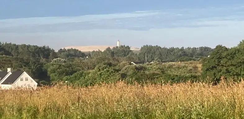 Udsigt fra campingpladsens fodboldbane mod Lønstrup Udsigt fra campingpladsens fodboldbane over Lønstrup med klit og fyr i horisonten