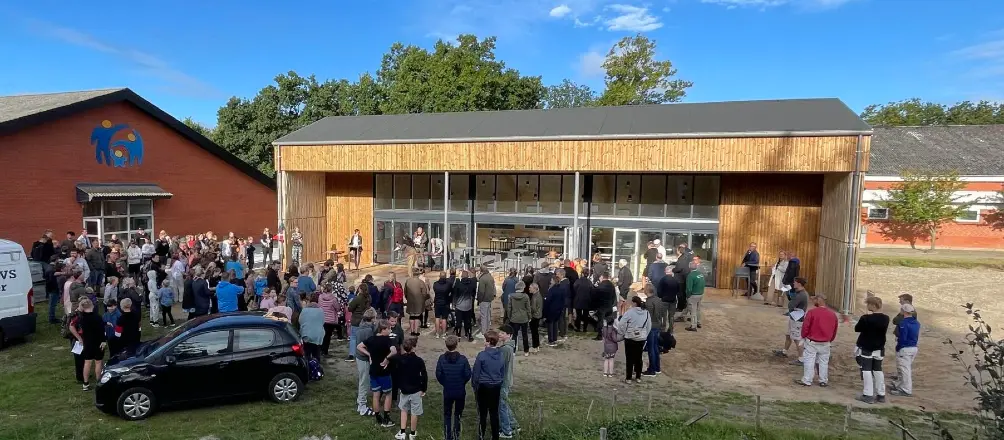 Friskolen Skallerup med elever, forældre og ansatte samlet foran skolens træbeklædte bygning