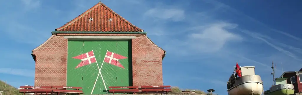 Lønstrup Gamle Redningsstation med de karakteristiske grønne porte og danske flag