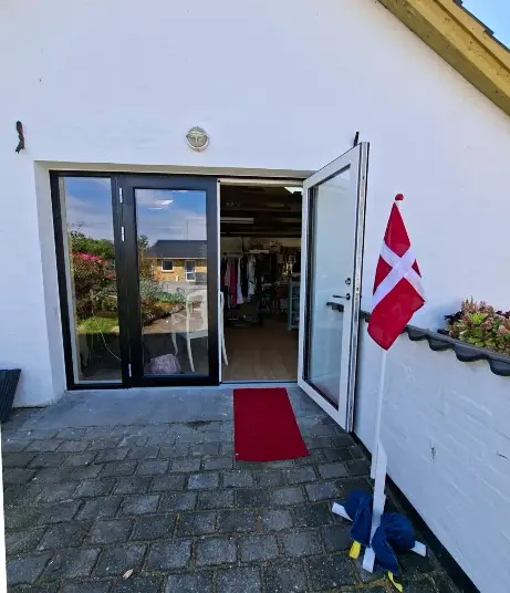 Sysmedjen Lønstrup – indgang med dannebrogsflag og rød løber